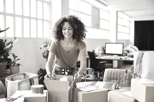 Female small business owner unpacks boxes of online orders
